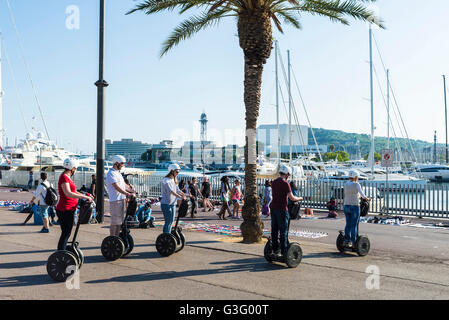 Les touristes sur un segway dans la promenade du front de mer plein de touristes et avec un marché aux puces à Barcelone, Catalogne, Espagne Banque D'Images