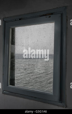 Fenêtre donnant sur la mer, dans l'île de Mykonos, Grèce, sur un jour de pluie Banque D'Images