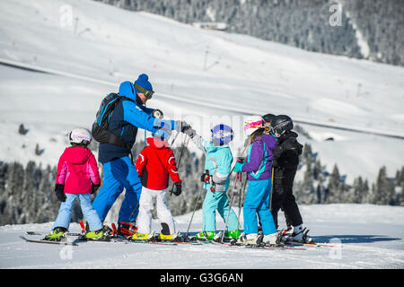 Un moniteur de ski enseigne à un groupe d'enfants dans la station de ski française de Courchevel. Banque D'Images