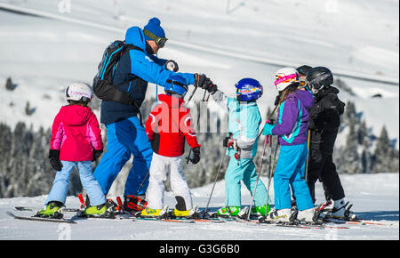 Un moniteur de ski enseigne à un groupe d'enfants dans la station de ski française de Courchevel. Banque D'Images