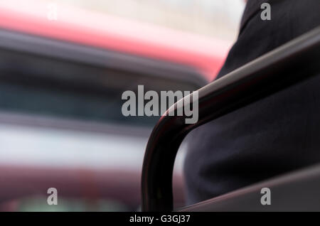 Homme assis sur les bus de Londres avec vue sur le bus qui passe Banque D'Images