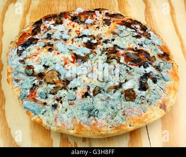 Pas frais, pizza moisi sur la table en bois Banque D'Images