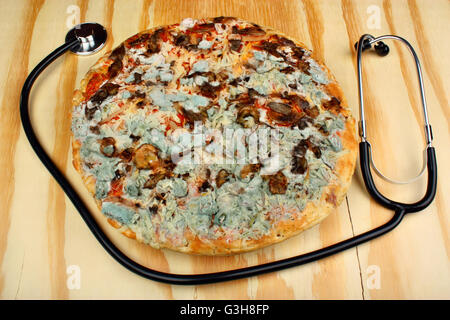 Vieux moldy pizza sur une table en bois. L'intoxication alimentaire Banque D'Images