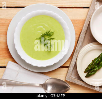 Soupe d'asperges dans un bol sur une table en bois Banque D'Images
