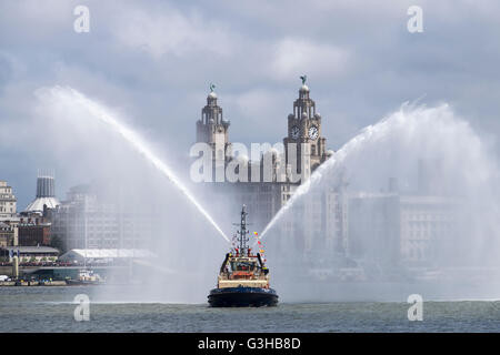 Pulvériser de l'eau bateau-pilote avec le foie bâtiment derrière, Liverpool, Merseyside, Angleterre Banque D'Images