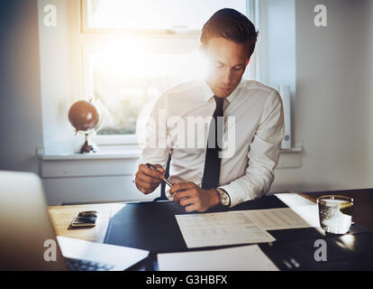 Executive business man working at desk dans un bureau classique tout en portant un costume et une cravate Banque D'Images