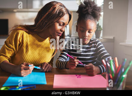 Maman et enfant dessin dans cuisine, mère et fille noire Banque D'Images