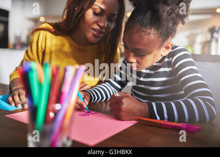 Maman et enfant dessin dans cuisine, mère et fille noire Banque D'Images