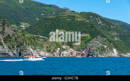 Les touristes sur un bateau arrivant à Vernazza, l'un des cinq villages qui composent la région des Cinque Terre Banque D'Images