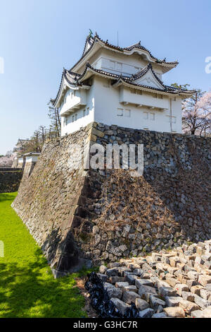 L'angle sud-tourelle, yagura Tatsumi, sur le dessus de la base de mur en pierre avec douves sèches et en arrière-plan l'ninomon gate. Château de Nagoya, au Japon. Banque D'Images