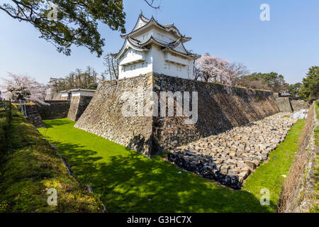 L'angle sud-tourelle, yagura Tatsumi, sur le dessus de la base de mur en pierre avec douves sèches et en arrière-plan l'ninomon gate. Château de Nagoya, au Japon. Banque D'Images