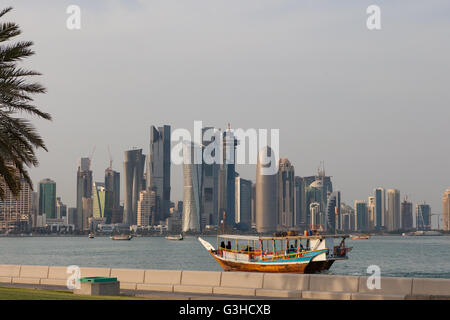 West Bay Doha vu de Al Corniche. Bateau Dhow avec femmes qataries dans Abayas au premier plan. Banque D'Images