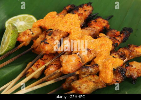 Sate, Serepeh poulet satay de Rembang, Central Java. Le satay sont servis sur des feuilles de bananes-bordée de cocotiers de la plaque de bois. Banque D'Images