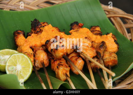 Sate, Serepeh poulet satay de Rembang, Central Java. Le satay sont servis sur des feuilles de bananes-bordée de cocotiers de la plaque de bois. Banque D'Images