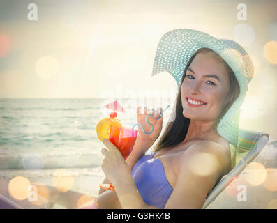 Portrait de jeune femme assise sur une chaise longue avec un cocktail au Miami Beach, Floride, USA Banque D'Images