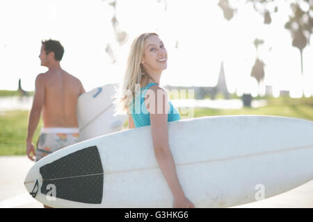 Jeune femme surfer à la recherche de retour à Venice Beach, California, USA Banque D'Images