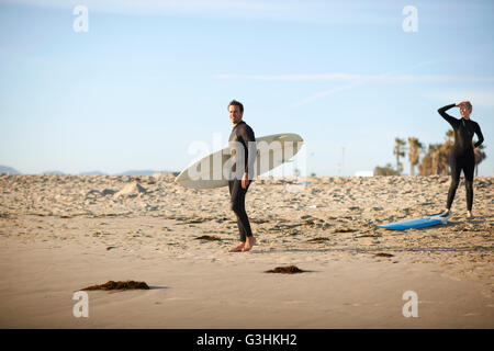 Couple avec des planches de surf sur la plage de Venice, California, USA Banque D'Images