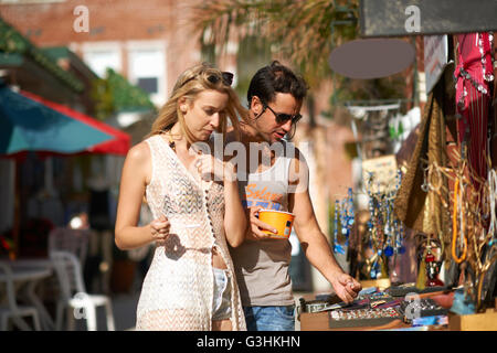 Couple eating le yogourt glacé et bijoux navigation décroche à Venice Beach, Californie, USA Banque D'Images