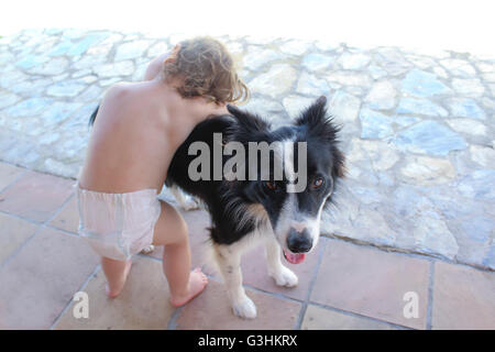 Toddler hugging pet dog Banque D'Images