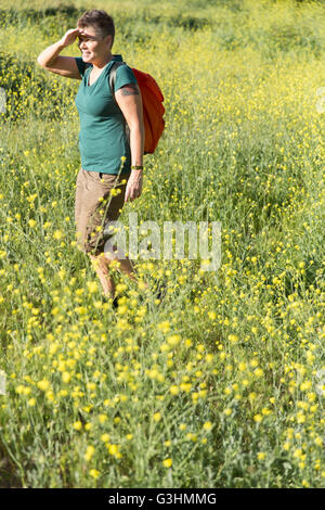 Femme randonneur dans une prairie de fleurs sauvages à l'écart des yeux de blindage Banque D'Images