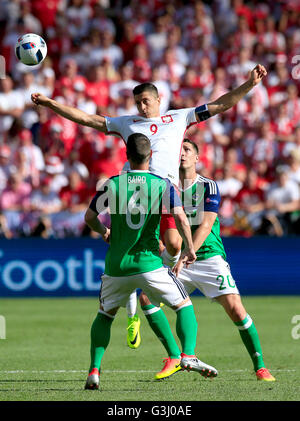 Robert Lewandowski Pologne (centre) en action avec l'Irlande du Nord Chris Baird (à gauche) et Craig Cathcart (à droite) au cours de l'UEFA Euro 2016, Groupe C match au stade de Nice, Nice. Banque D'Images