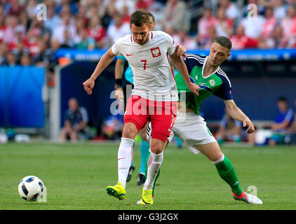 La Pologne Arkadiusz Milik (à gauche) et d'Irlande du Nord Chris Baird bataille pour la balle durant l'UEFA Euro 2016, Groupe C match au stade de Nice, Nice. Banque D'Images