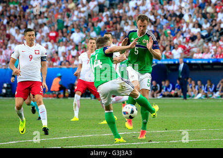 L'Irlande du Nord Stuart Dallas (centre) et Jonny Evans (à droite) s'attaquer les uns les autres comme ils vont à la même balle au cours de l'UEFA Euro 2016, Groupe C match au stade de Nice, Nice. Banque D'Images