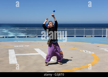 Man juggling sur le pont de la Brittany Ferries MV Pont-Aven cruiseferry naviguant entre Portsmouth et Santander. Banque D'Images