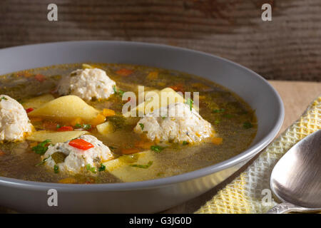 Soupe avec des boulettes de viande et les nouilles en plaque sur fond de bois Banque D'Images