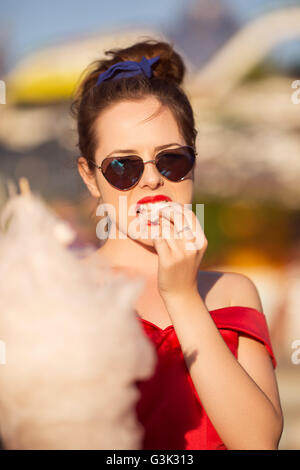 Jeune femme à Luna park eating Cotton Candy Banque D'Images