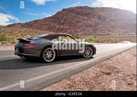 Vue latérale d'une Porsche 911 Carrera S sur une route de montagne du désert Banque D'Images