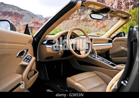 L'intérieur, planche de bord, le volant et la console d'une Porsche 911 Carrera S sur une route de montagne du désert Banque D'Images