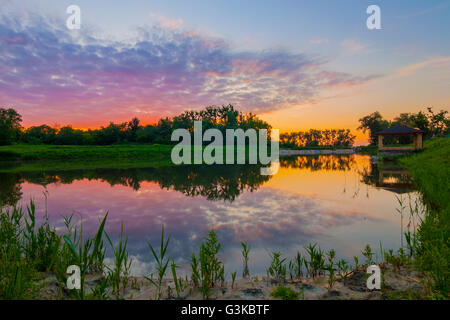 Belle alcôve sur un lac au coucher du soleil soir Banque D'Images