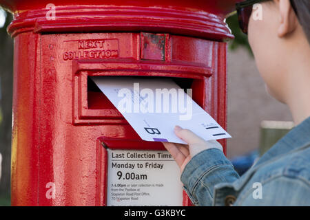 Une jeune femme l'affichage d'un scrutin postal au Royaume-Uni. Banque D'Images