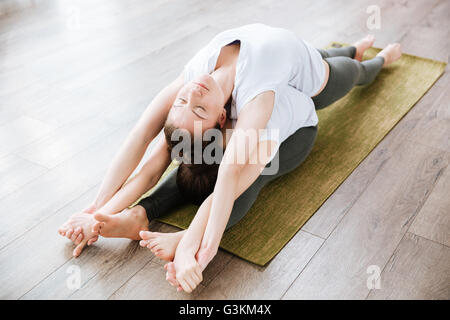 Deux jeunes femmes détendue des étirements et de la pratique du yoga en studio Banque D'Images