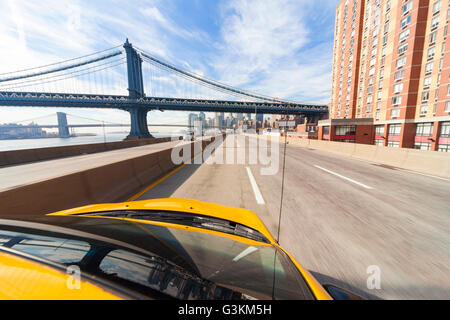 New York City taxi jaune de la conduite sous le pont de Manhattan Banque D'Images