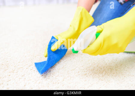 Spray de nettoyage de tapis. Close-up. Se concentrer sur un gant et le tapis. Banque D'Images