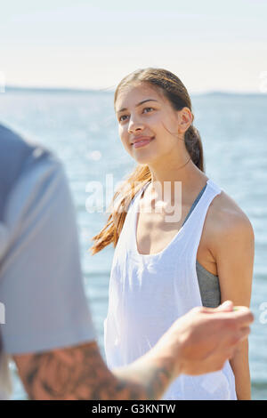 Femme en face de l'ocean à la recherche à l'ami smiling Banque D'Images