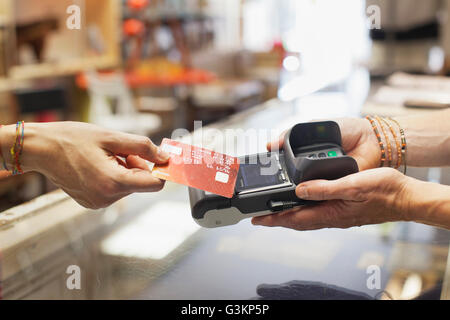 Portrait de la main à l'aide de la femme carte de crédit pour effectuer le paiement sans contact sur carte à puce et NIP machine Banque D'Images