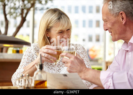 Couple mature dating soulever un verre de vin blanc au restaurant table Banque D'Images