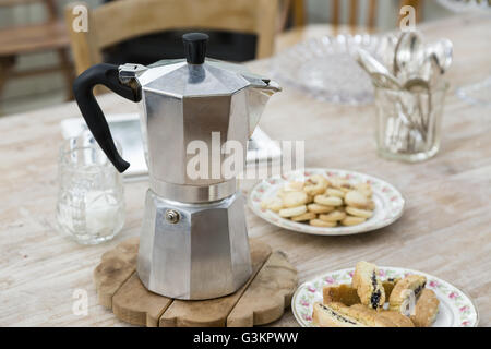 La cuisinière avec plaques de pot de café de bonne boulangerie sur table à manger Banque D'Images