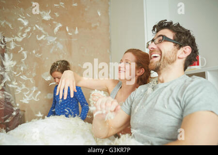 Couple pillow fighting fille au lit Banque D'Images