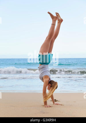 Young woman doing handstand on beach, la République dominicaine, les Caraïbes Banque D'Images