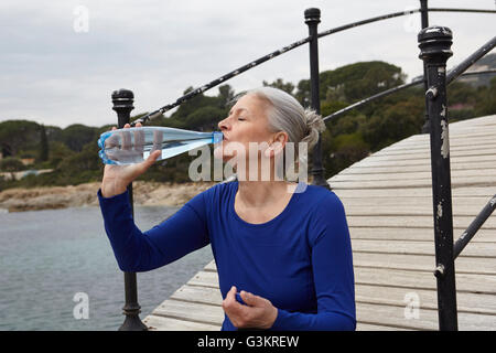 Femme mature en plein air, bouteille d'eau potable à partir de Banque D'Images