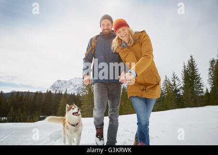 Portrait of couple walking husky dans la neige paysage, Elmau, Bavière, Allemagne Banque D'Images