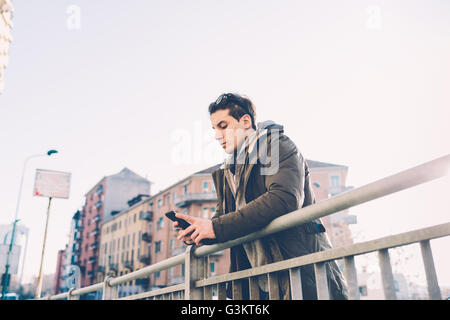 Man using smartphone garde-corps Banque D'Images