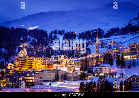 Village de montagne sous la neige sur le paysage couvert de lumière le soir, Sankt Moritz, Suisse Banque D'Images