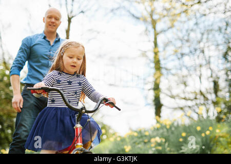 L'enseignement du Père fille à circuler à bicyclette Banque D'Images