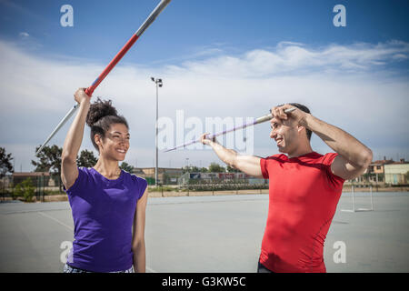 Instruire l'homme lancer du javelot féminin sur un terrain de sport Banque D'Images