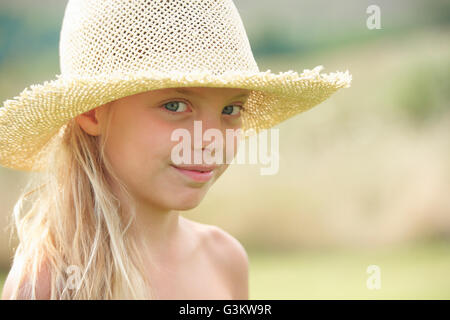 Portrait de jeune fille à l'extérieur, wearing straw hat Banque D'Images